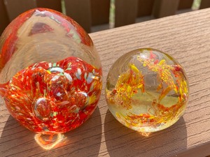 lot 12 image: Two Paper Weights in Shades of Orange and Yellow