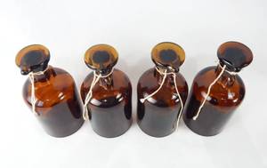 lot 192 image: Set of 4 Vintage Mercer Glass Works Merco 125 ML Amber Glass Flat Top Grooved Stopper Dropping Bottles