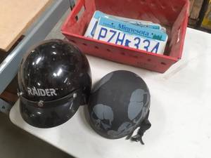 lot 73 image: Small Bin with several expired MN License Plates, a motorcycle helmet as well as a skateboard helmet