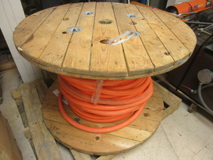 lot 703 image: LARGE WOODEN SPOOL OF THICK ORANGE WIRE