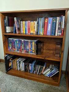 lot 217 image: Wood Bookshelf Filled with Movies & Books