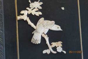2-panel wood screen with images made from shell or stone.