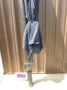Canitlevered patio umbrella. Blue in color. Appears new. Approximately 10 in diameter. As shown.