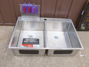 Stainless steel dual compartment sink. Looks like it may have been a store display As shown.