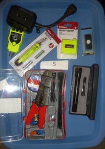wire stripping electrical kit, metal flashlight, battery tester, and chirper and outlet tester and remote control