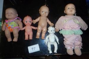group of vintage dolls, far left is a berenger, 3 kewpies, one is ceramicporcelain connected with string, all moveable joints