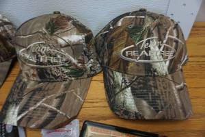 lot 59 image: 3 Team Real Tree Baseball Caps With Ear Plugs and Game Tag Kit