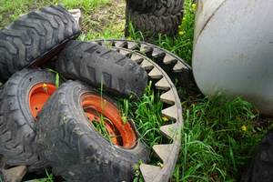 lot 14 image: Set of 5 - Bobcat Skid Loader Skid Steer Tires On 8 Bolt Rims With Pair of Over The Tire Rubber Tracks