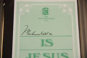 lot 1 image: Muhammad Ali Autograph Pamplet PSADNA Authentic Auto Encased COA