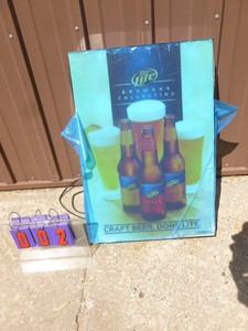 lot 2 image: Miller Lite Brewers collection sign. NOS. Still has plastic on face. Very limited production. Beer was test marketed in the twin cities & only lasted a year. As shown.