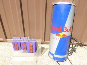lot 6 image: Red Bull hanging sign shaped like 12 can. 20 x 8. As shown.