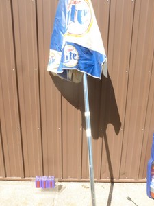 lot 11 image: Miller Light vinyl patio umbrella. Good used condition.