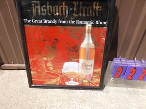 lot 22 image: Asbach-Urault german brandy framed sign. 21 x 18. Looks unused. As shown.