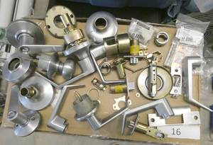 lot 16 image: Group of spare handles, strikeplates and parts for commercial doors