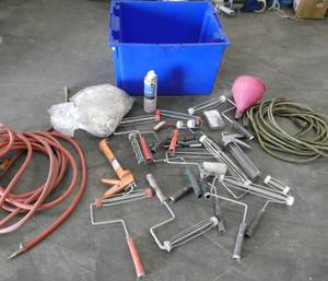 lot 98 image: Blue tote full of misc supplies, air hose, extension cord, paint rollers, caulking guns, cleaning rags