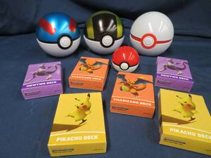POKEMON BALLS, CARD BOXES, AND A STACK OF CARDS