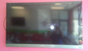 lot 7 image: Sony Bravia 55 in. Flatscreen TV with wall mount bracket and remote.