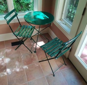 Green outdoor patio table with 2 chairs.