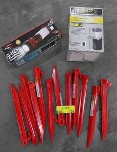 lot 134 image: New Camping items, tent stakes, and 2 lanterns