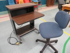 lot 105 image: Work desk with electrical hookup and comfortable blue chair