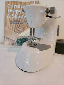 lot 15 image: Dressmaker Portable Electric Sewing Machine & Decorating Book