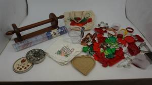 lot 29 image: One Dark Brown Wooden Paper Towel Holder-Pastry Mat-Bag Of Cooky Cutters-Five Maple Leaf Decorative Cutters-Heart Trivet-Dishtowel