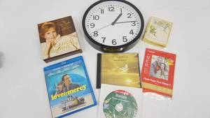 lot 85 image: Black Plastic Quartz Clock-Carol Burnett Audio Compact Disk-Love & Mercy Blu-Ray DVD-Canon Glossy Photo Paper-Wind Beneath My Wings CD-Italian Phrases & Expressions-Box Of Bookplates