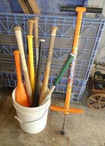 lot 175 image: A pail full of wood, aluminum and plastic  baseball bats and a pogo stick
