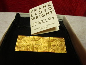 lot 434 image: FRANK LLOYD WRIGHT JOHN STORER HOUSE 22 KT. GOLD-PLATED JEWELRY PIN, ISSUED BY MOMA