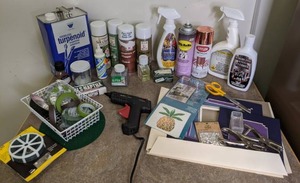 lot 164 image: Mixed Craft Lot of Spray Paints, Dried Flower Sealant, Glitter, Glue Gun, Hole Punchers, Flower Tape, & More.