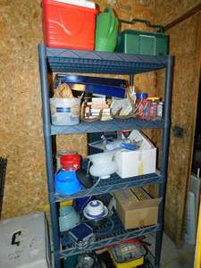 lot 63 image: Five Shelf Storage Shelves- Red Coleman Cooler-Green Watering Can-Green Cooler- Nine Books-Deer Antlers-Three Containers W  Misc. Things Inside  Blue Dog Dish-Reel W Rope On It-Professional Cleaning Kit  Some Drinking Glasses--Etc.
