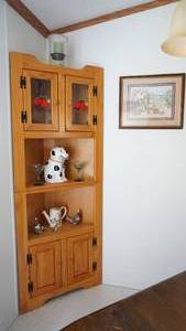 lot 103 image: A Corner Four Door Two Shelves Display Cabinet--Framed & Matted (Gods Handprint)--Glass Candle Holder W candle Inside--Two Champagne Glasses--Ceramic Puppy W Bone In Mouth--Three Bird Figurines--One Water Pitcher