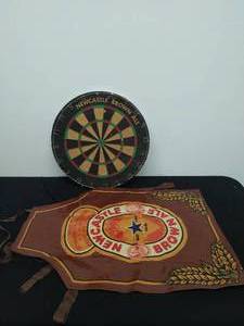 lot 102 image: Vintage New Castle Brown Ale Dart Board with Apron and Darts