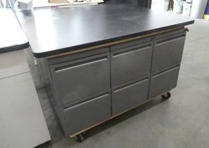 lot 147 image: Rolling work cabinet table - made out of 6 file cabinets, with a formica table top on wheels.  Rolls very well, all the drawers open. Measures 48x51 on top, 35 tall