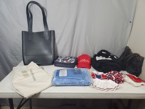 lot 58 image: American Girl Doll Clothing, Hunter Bag, Satin Sheets, and More