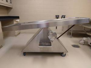 lot 43 image: WOW MSRP $8,000 Heavy Gauge Stainless Steel Hand Crank Tilting Floating Mobile Autopsy Table Cart With Drainage Area & Slide Out Step Stool - Great Working Condition  See Pictures