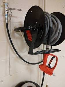 lot 117 image: Hotsy Pressure Washer Red Trigger Gun (Can handle 5000psi), Hose & Wall Mount Rack Only - Great Condition - No Pressure Washer Mechanism (Had been wired into building) 
