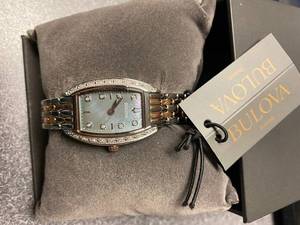 lot 126 image: Bulova Tonneau Two-Tone Black Mother-of-Pearl Dial Ladies Quartz Watch The retail price in Costco $359.99