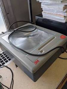 lot 247 image: 3M Overhead Projector, Emerson Microwave and a Stack of Loose Leaf Paper