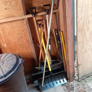 lot 218 image: Corner Full of Snow Shovels, Edger, Poles, Pick Axe, and More 