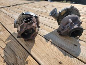 lot 57 image: 2 turbochargers for a Ford 7.3. One is an OEM turbo, one is an upgraded ball bearing bigger turbo