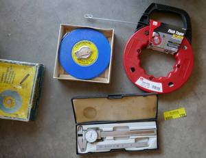 lot 198 image: 100 ft measuring tape, 50 ft fish tape and a micrometer