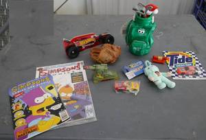 lot 234 image: Group of toys including Simpsons comics, a Talking heckling golf bag, a Oscar Meyer weiner mobile, a cardboard Hot Wheels, mini baseball glove, Tide hot wheels car and more