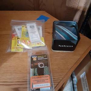 lot 773 image: new in package Hoppes bore snake rifle cleaner, new in tin VanHeusen mens necktie along with a zip lock baggie containing multiple Custom jigs and spins flu-flu ice