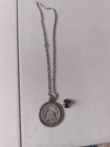 lot 522 image: Hanging from a silver toned chain i...