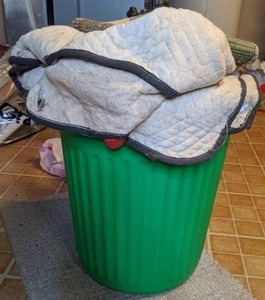 lot 174 image: Green Hamper with Misc. Bedsheets, Towels, Rug, & More
