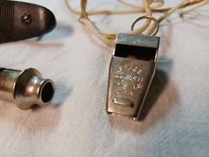 lot 219 image: Two Whistles Olympia Brass Whistle, A Whistle on a Key Ring,  and a Firearm Butt Plate