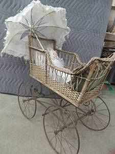 lot 103 image: ANTIQUE BABY CARRIGE, UNBRELLA, BABYDOLL WITH STUNNING DRESS,  PILLOWS AND A BEAUTIFUL CROCHETED FLORAL PIECE