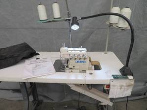 JUKI SURGER SEWING MACHINE WITH ROLLING MACHINE TABLE.