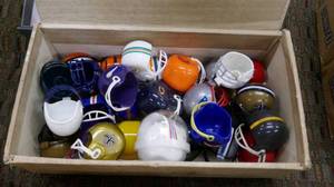lot 47 image: cigar box full of miniature football helmets of various teams